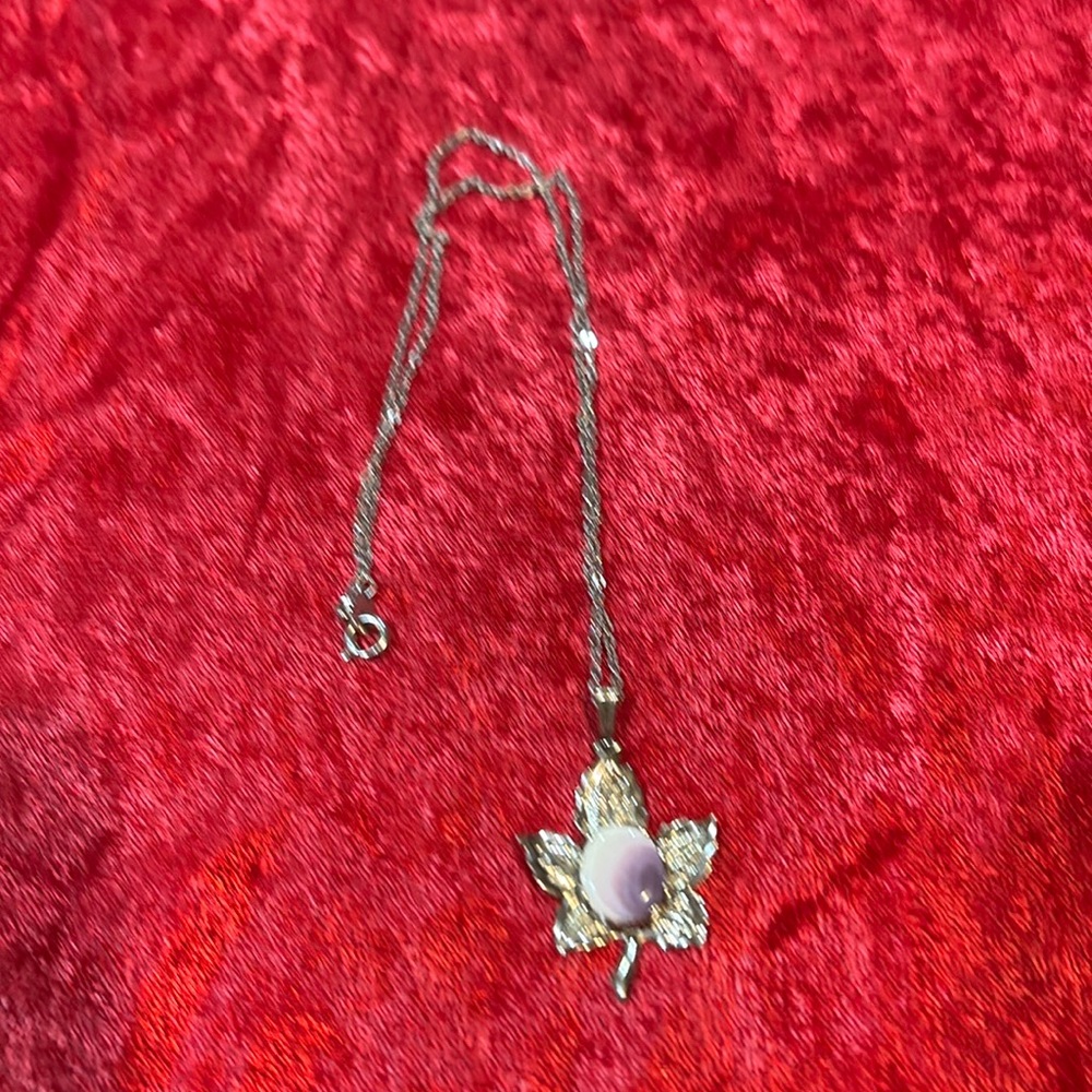 Necklace leaf shape with a purple and white stone. 15” chain